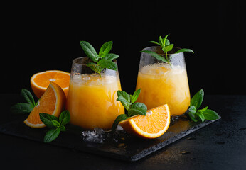 Cold summer orange lemonade with mint and ice in a glass. Copy Space for text