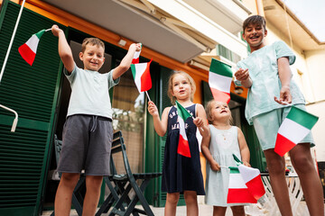 Fototapeta premium Happy four kids with italian flags celebrating Republic Day of Italy.