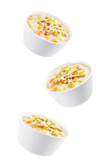 Fresh hot chowder soup with fried bacon slices and shredded cheese in a bowl on a white isolated background