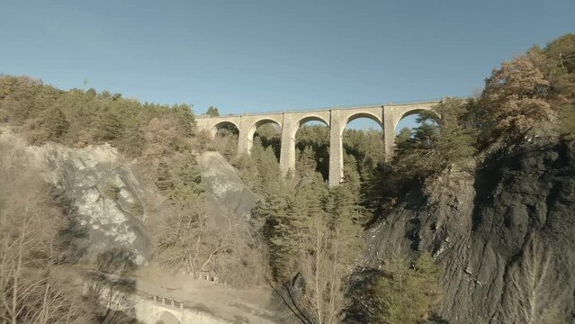 Dynamic FPV drone view around stone bridge in rural area