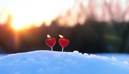 red candles heart on snow, abstract blurred natural background. beautiful winter landscape with...