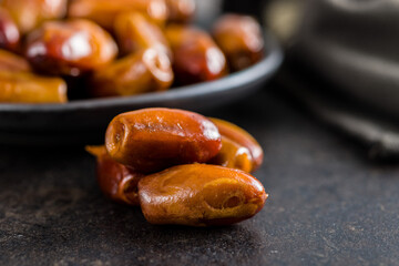 Dried dates fruit on black table.