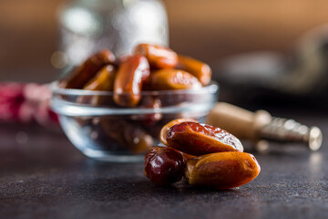 Dried dates fruit on black table.