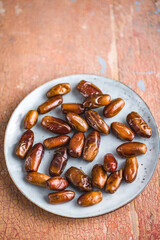 Dried dates fruit on plate.
