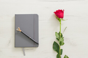 A delicate bouquet of flowers, an empty notebook, a glider for women, a calendar-glider on a wooden...