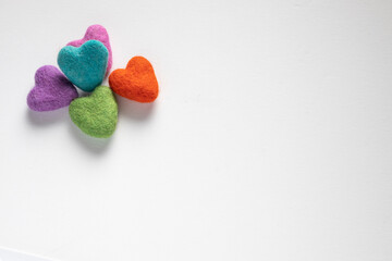 Pile of colourful felt hearts on a white background