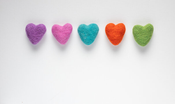 Colourful felt hearts on a white background