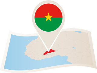 Folded paper map of Burkina Faso with flag pin of Burkina Faso. 