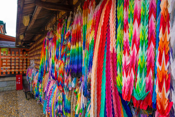 This image shows thousands of carefully folded origami paper cranes in many colors.