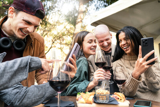 Young Friends Having Fun Drinking Red Wine At Winery Bar Outdoors- Happy Cheerful People Looking Smartphone Sharing Social Content On Mobile Phone Together At Restaurant-Youth Lifestyle Concept