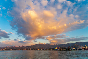 Beautiful natural seascape at sunset time with bright colorful clouds over mountains and sea.