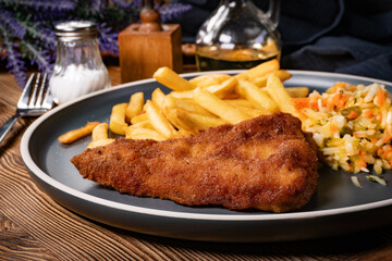 Fried cod fillet with fries and salad.
