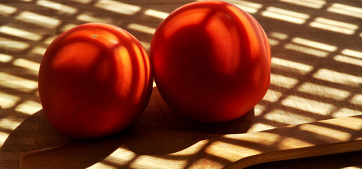 Fresh tasty tomato, all organic tomato, next to a wooden spoon