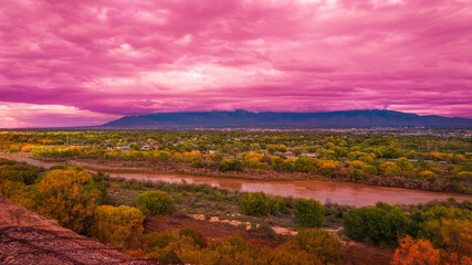 Stormy pink sunset cloudscape over Albuquerque skyline, autumn landscape with colorful cottonwood trees over Rio Grande River, New Mexico, USA
 - obrazy, fototapety, plakaty