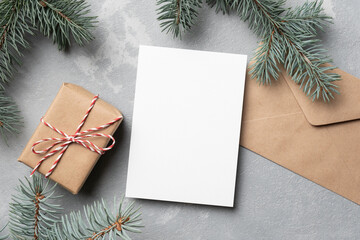 Fototapeta na wymiar Christmas mockup with empty greeting card, fir tree branches and gift box