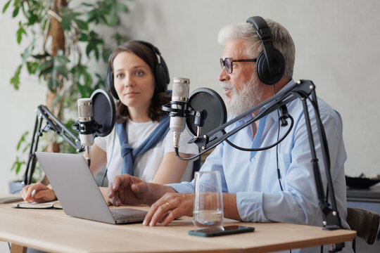 older man and female presenter in a recording studio create a podcast. senior, woman radio presenter or interviewer. business dialogues, marketing. recording audio content for social media online
