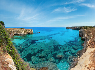 Picturesque seascape with cliffs, rocky arch and stacks (faraglioni), at Torre Sant Andrea, Salento sea coast, Puglia, Italy.
