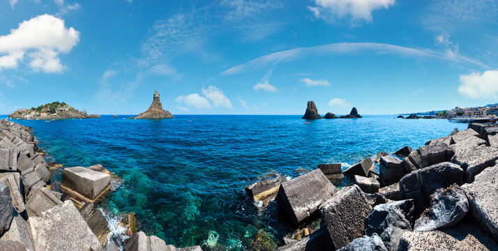 Lachea Island on Cyclopean Coast and the Islands of the Cyclops on Aci Trezza town (Italy, Sicily,10 km north of Catania). Known as Isoles Dei Ciclopi Faraglioni. People are unrecognizable.