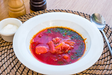 Borscht with sour cream on white bowl