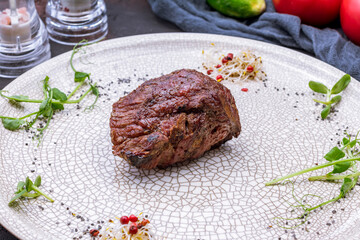 grilled steak filet Mignon on grey plate on dark stone table macro close up