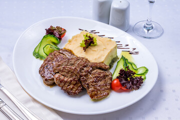 medallions of beef with mashed potatoes on white table