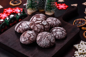 Delicious fresh brownies with Christmas decorations on a dark concrete background