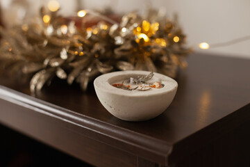 Natural aromatic organic  vegan candle with herbs and citrus. Artisanal handmade Christmas decoration. Cozy home accessories. Hobby of creating natural wax candles.