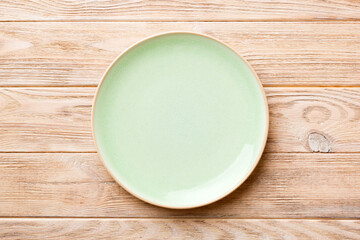 Top view of empty blue plate on wooden background. Empty space for your design