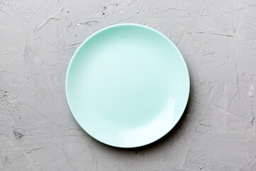 Top view of empty blue plate on cement background. Empty space for your design
