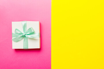 holiday handmade white present tied green ribbon bow top view with copy space. Flat lay holiday background. Birthday or christmas present. Christmas gift box concept with copy space