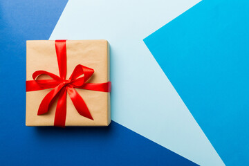 holiday brown paper present tied red ribbon bow top view with copy space. Flat lay holiday background. Birthday or christmas present. Christmas gift box concept with copy space