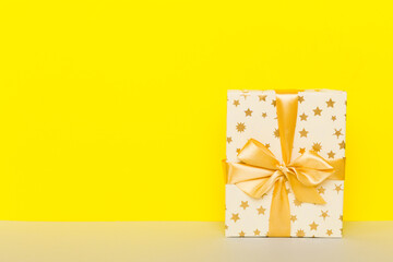 holiday paper present tied yellow ribbon bow top view with copy space. Flat lay holiday background. Birthday or christmas present. Christmas gift box concept with copy space