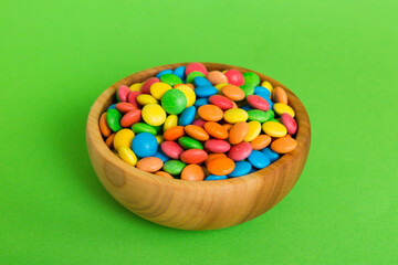 Multicolored candies in a bowl on a colored background. birthday and holiday concept. Top view with copy space