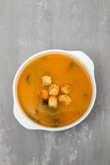 vegetable soup with crackers in white bowl on ceramic