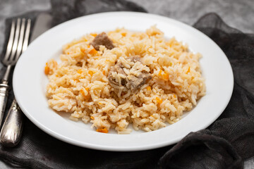 Rice with vegetables and meat on white plate