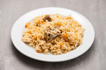 Rice with vegetables and meat on white plate