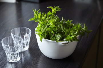 Fresh mint herb leaves in white bowl on wooden kitchen table. Green mint bunch. Cooking beverage with fresh mint ingredient © mikeosphoto