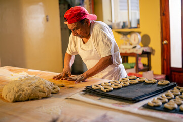 Retrato de un hombre adulto trabajando en una panaderia. Hombre haciendo roscas, pan, pasteles, galletas, pizza artesanales. 