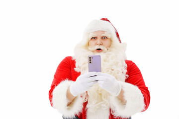 Santa Claus is surprised with a smartphone in his hands on a white background. 