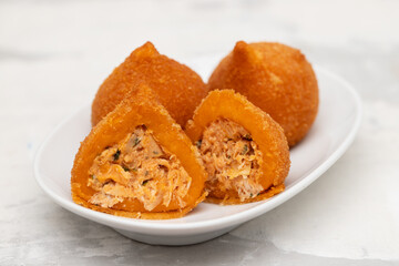 traditional brazilian fried drumsticks Coxinha de frango on a small dish