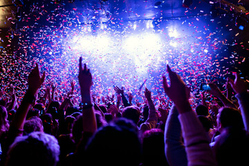 Crowd at a concert celebrating with confetti