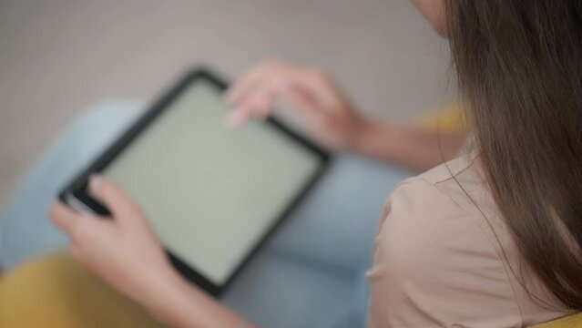 Girl browsing web and looking through photos on digital tablet
