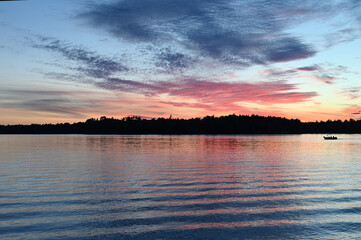 Pale sunset on a lake with silhouetted trees