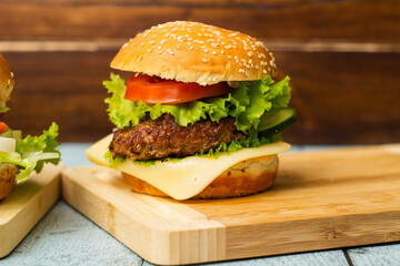 Tasty hamburger on wooden background