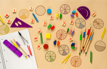 Set of supplies for mathematics and for school. Fractions, rulers, pencils, notepad on beige...