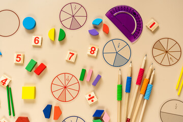 Set of supplies for mathematics and for school. Fractions, rulers, pencils, notepad on beige background. Back to school, fun education concept