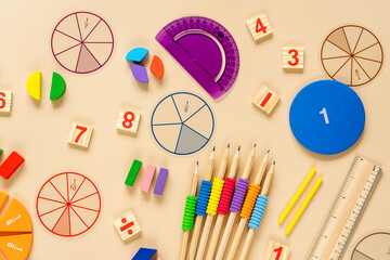 Set of supplies for mathematics and for school. Fractions, rulers, pencils, notepad on beige...