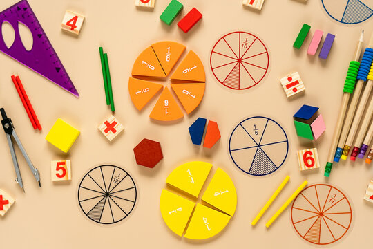 Set of supplies for mathematics and for school. Fractions, rulers, pencils, notepad on beige background. Back to school, fun education concept