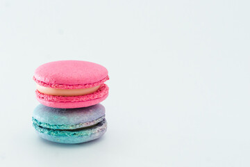 Brightly colored stacked up French macarons on white. Tasty colourful macaroons. Blue and pink macaroons isolated on white background. French pastry made from egg whites. Concept of food, desserts