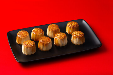 Chinese moon cakes on a black plate on a red background